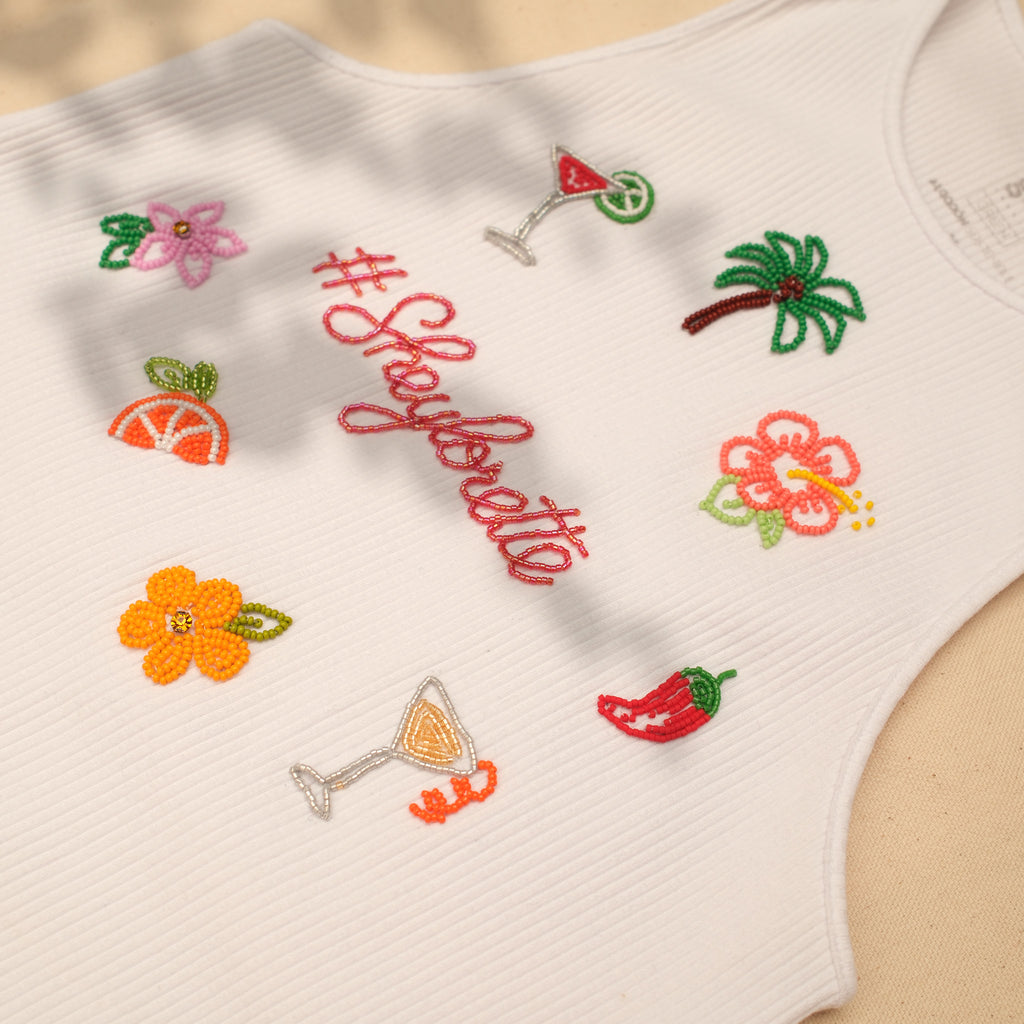 Esqueleto blanco con hashtag personalizado bordado en canutillo y motivos de palmera, hibisco y cóctel